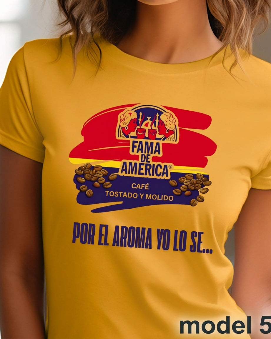 A woman wearing a mustard yellow graphic t-shirt with a colorful 'Fama de America' coffee print on the chest.