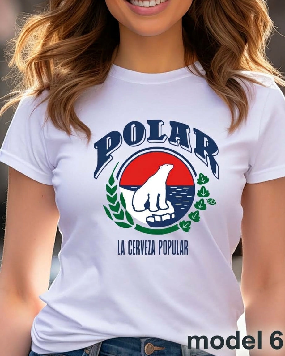 A woman wearing a white graphic t-shirt with a colorful print featuring a polar bear, the word 'POLAR', and the text 'LA CERVEZA POPULAR'.